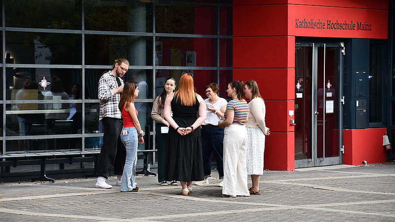 Gruppe von Studierenden und Anleitungen im Gespräch vor der Hochschule