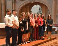Die acht Absolventinnen und Absolventen des Doppelstudiums stehen mit zwei Lehrenden bei der Abschlussfeier im Mainzer Dom für ein Gruppenfoto vor dem Altar.